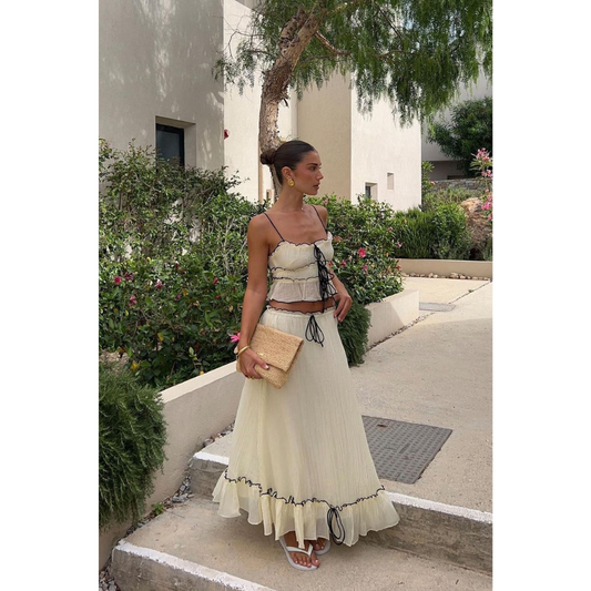 Cream maxi skirt set with black drawstring ties and ruffled hem, worn outdoors