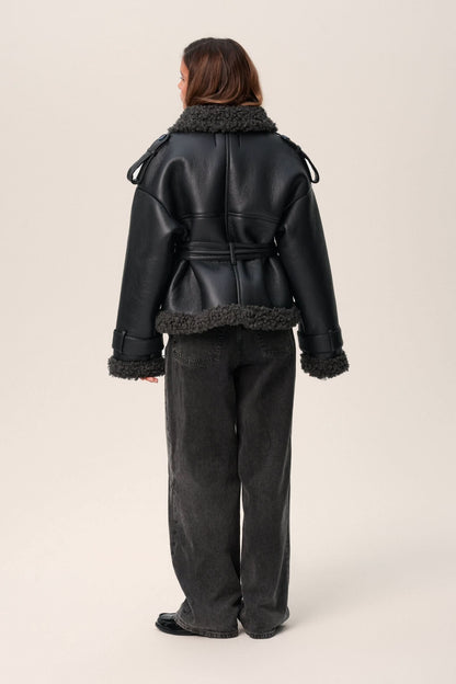 Back view of black leather cropped coat with charcoal fleece collar and hem