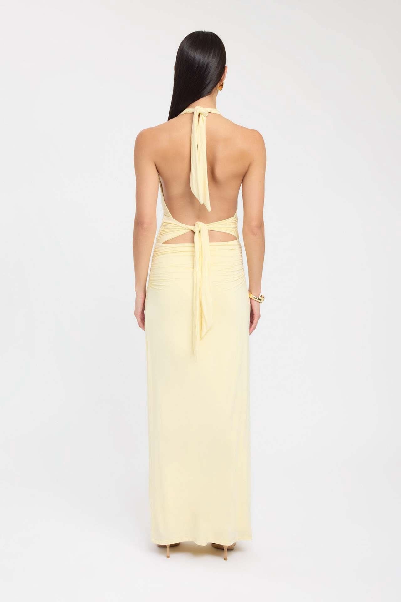 Back view of pale yellow maxi dress with halter tie and cutout details