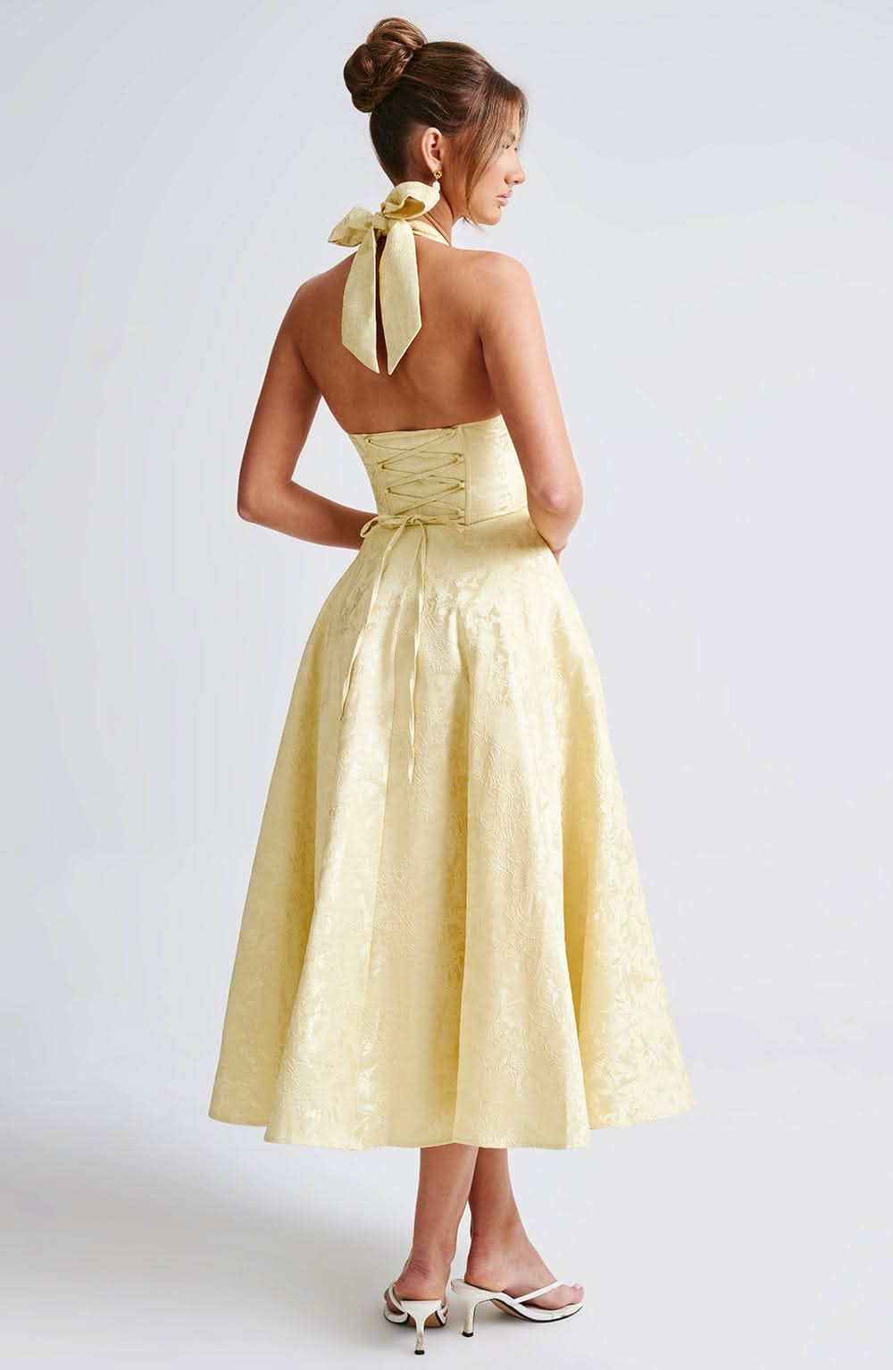 Back view of yellow midi dress with lace-up corset detail and bow tie