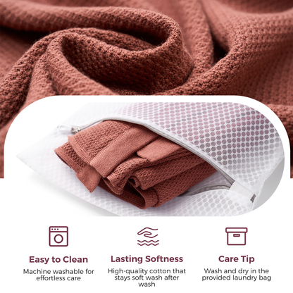 Rust-colored nursing cover folded in mesh laundry bag showing machine washable care instructions