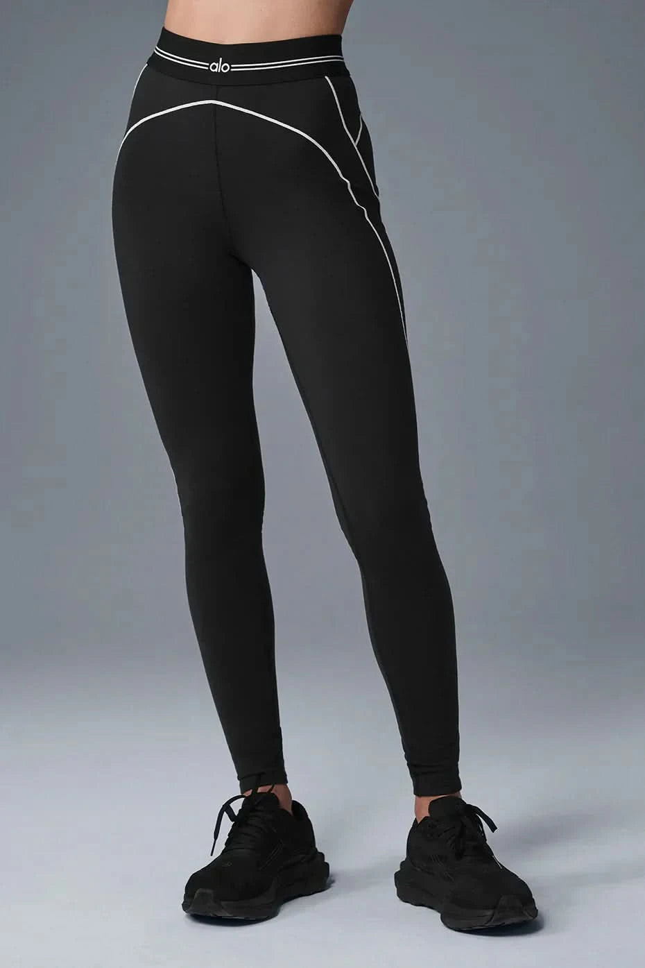 Black sculpting leggings with white curved seam lines and elastic waistband