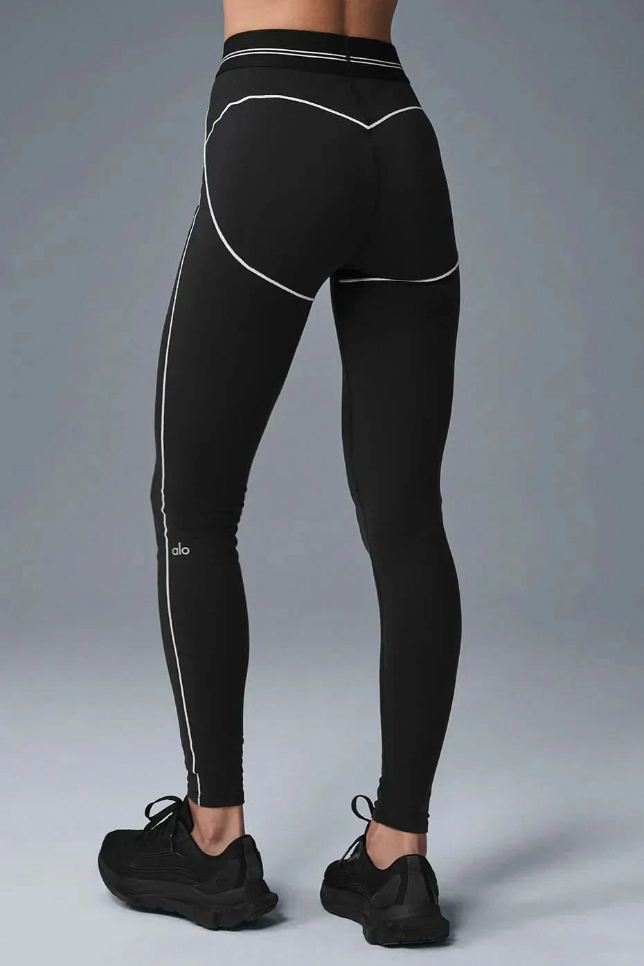Back view of black leggings showing white contour stitching and sculpted shape