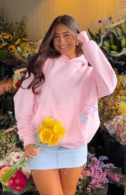 Pink Mae Star Hoodie front view with blue and pink star design and kangaroo pocket visible