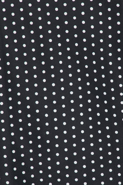 Close-up of black crepe fabric with white polka dot pattern detail