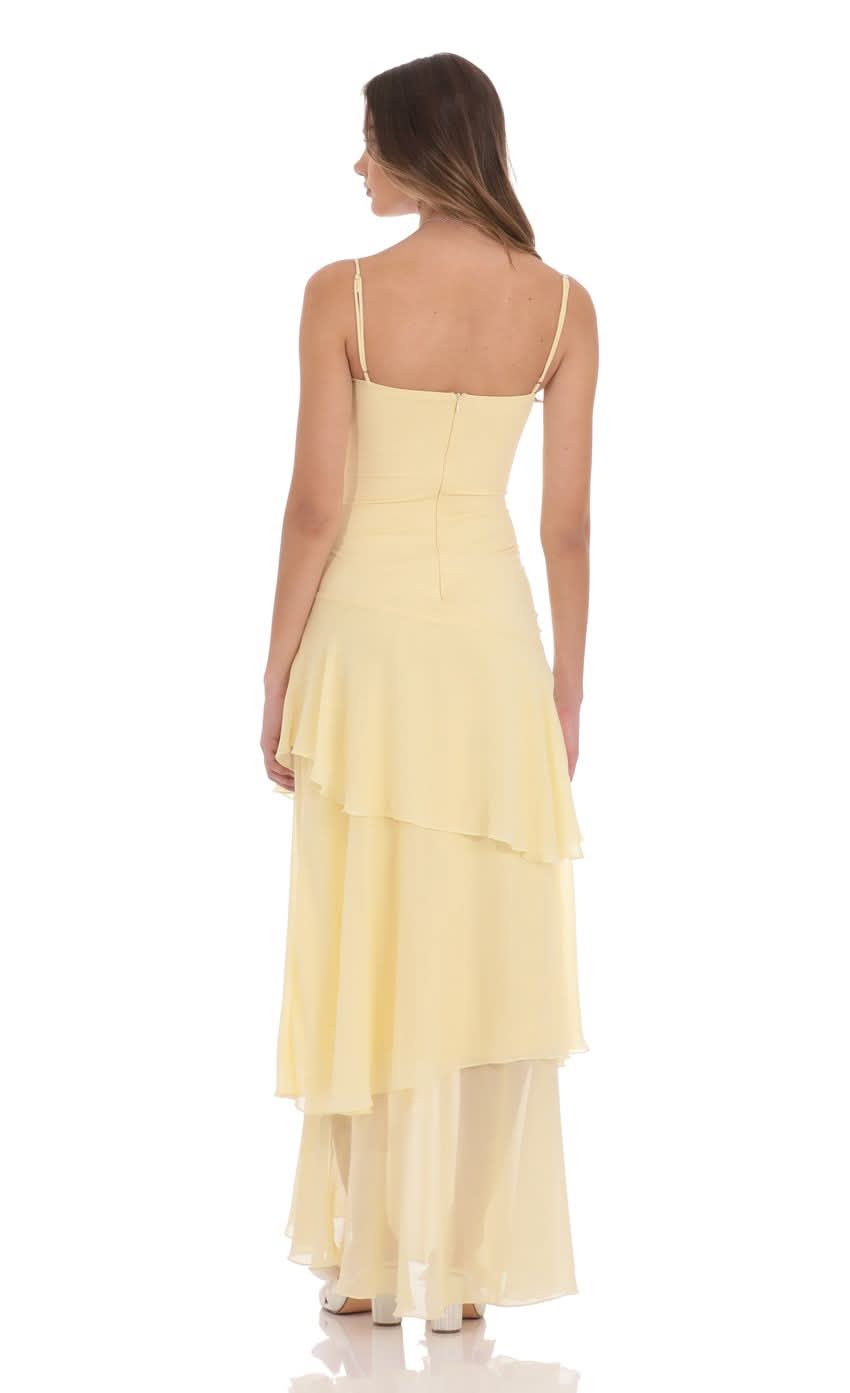 Back view of pale yellow maxi dress with cascading ruffle layers and center seam closure