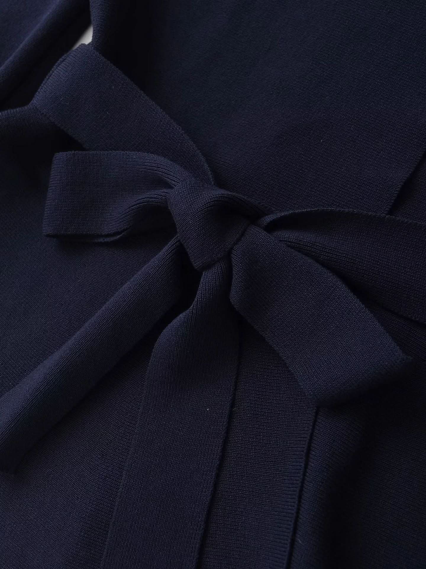 Textured navy fabric detail of cardigan tie and knit weave