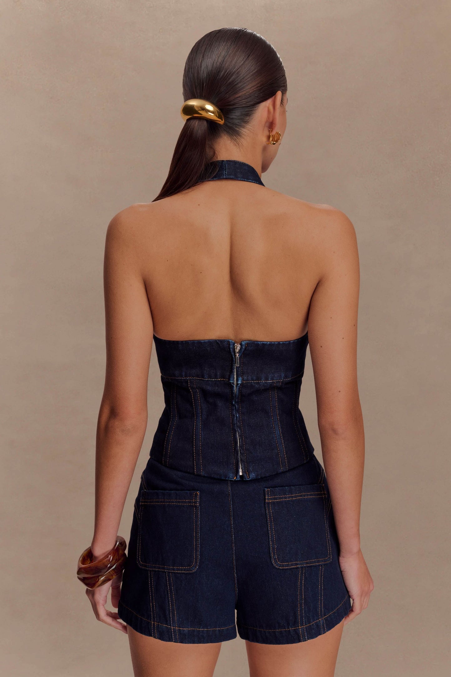 Back view of dark indigo denim halter top with open back design