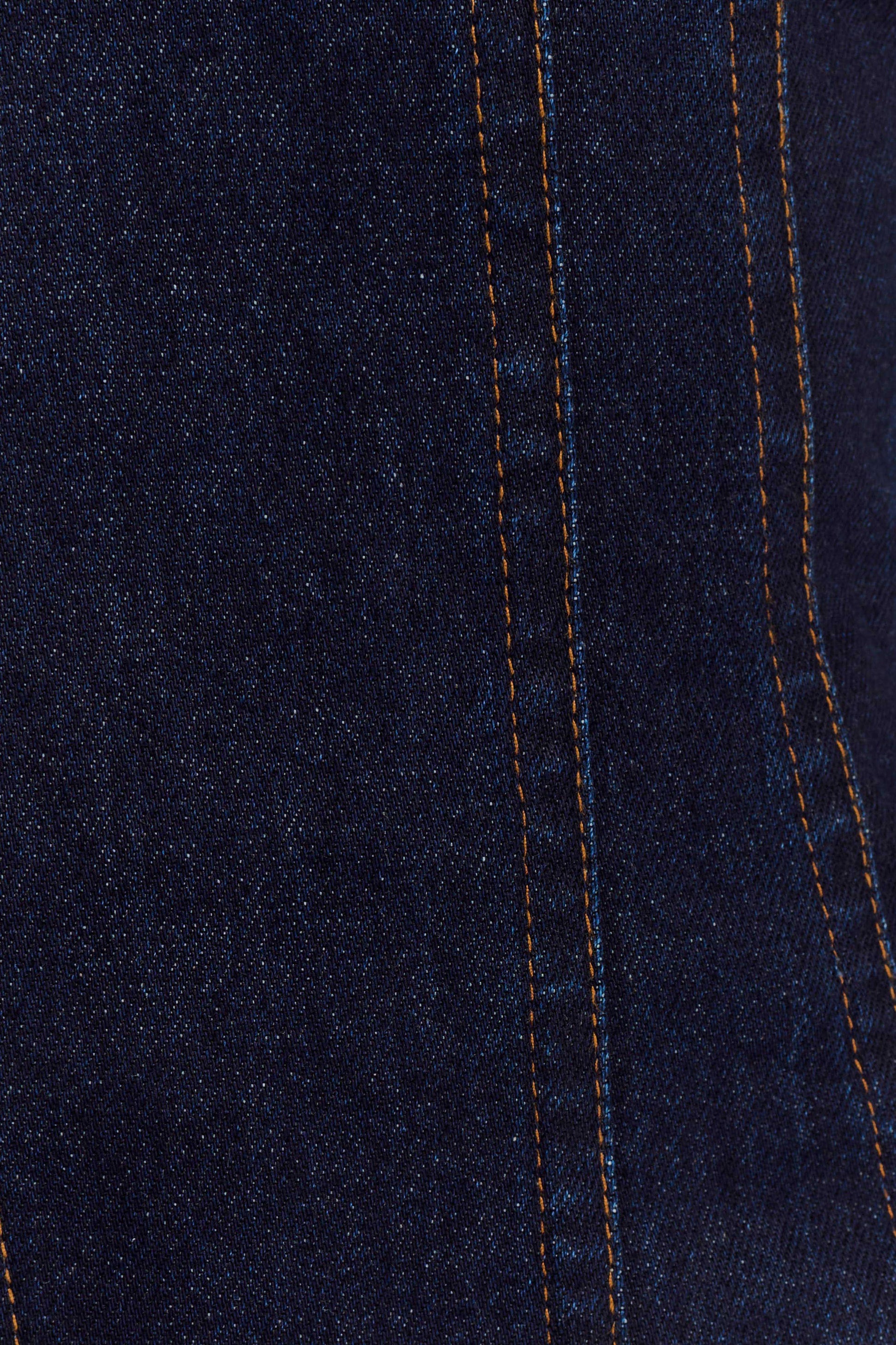 Dark indigo denim fabric close-up showing contrast orange stitching detail