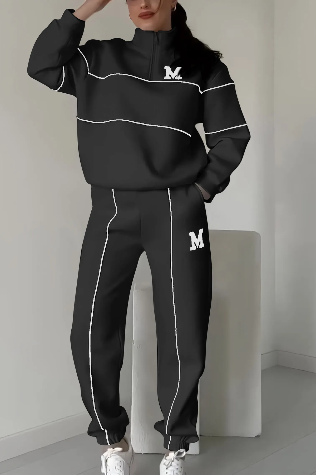 Black tracksuit with white piping and quarter-zip jacket