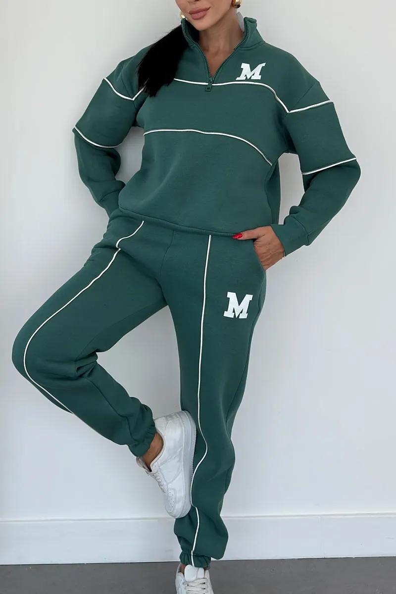 Dark green tracksuit with white piping and quarter-zip top