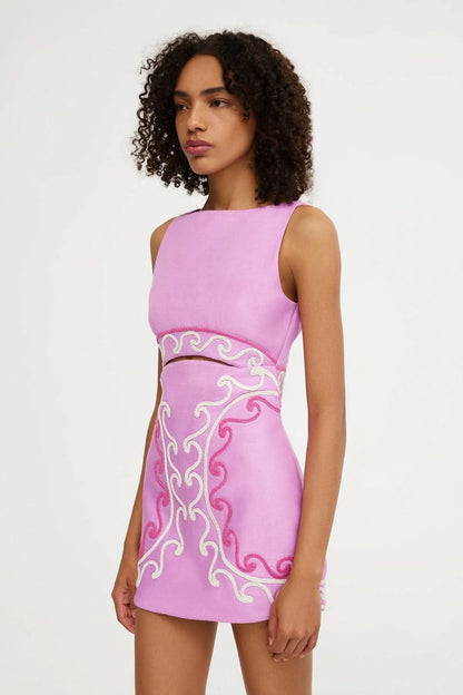 Side angle of women's pink mini dress with beaded embroidery and midriff cutout design