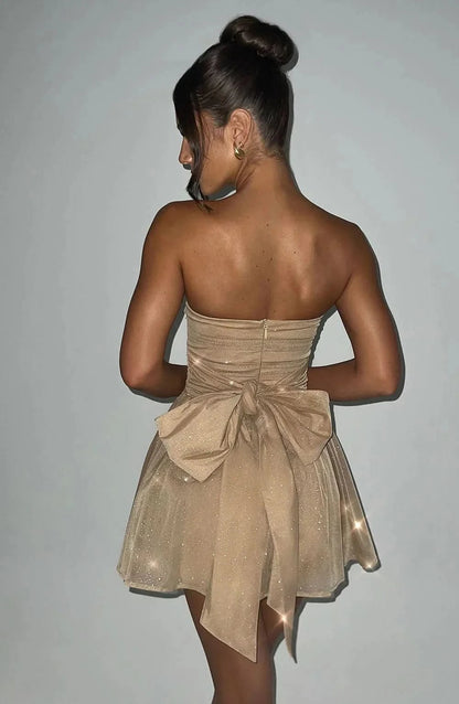 Back view of champagne glitter mini dress with bow detail