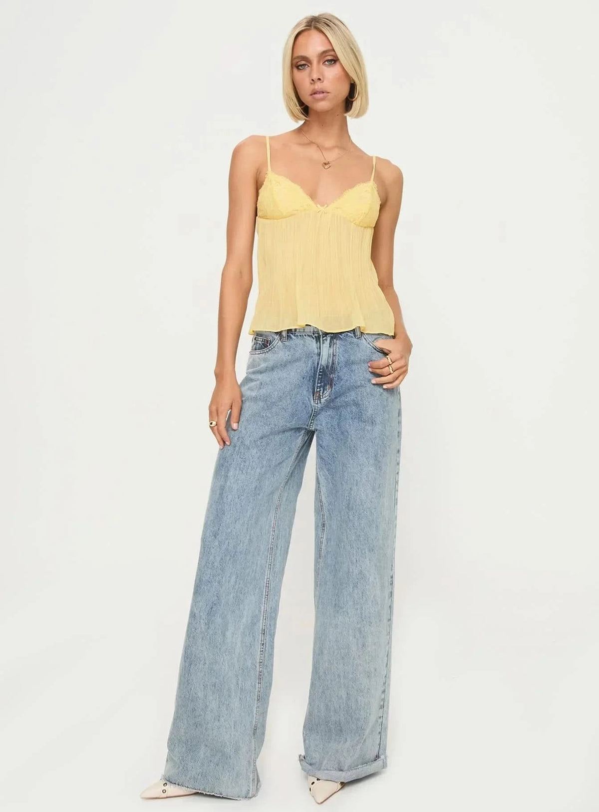Yellow pleated camisole with lace trim worn with light wash jeans