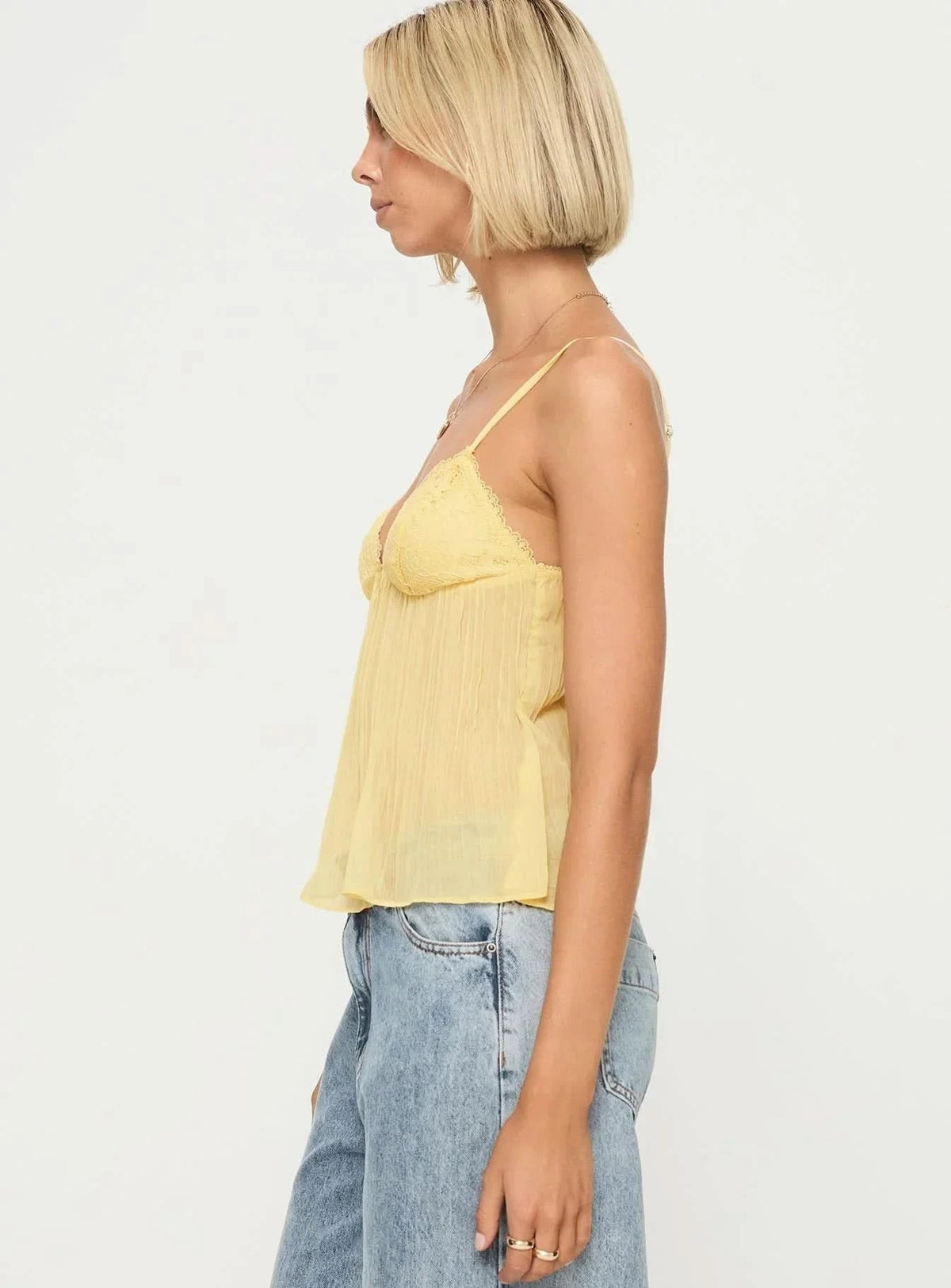 Side profile of yellow pleated lace camisole showing silhouette