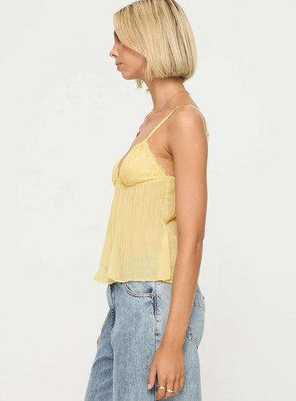 Side profile of yellow pleated lace camisole showing silhouette