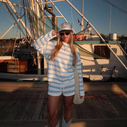 Blue and white horizontal stripe knit sweater and shorts on boat