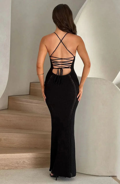 Back view of black maxi dress featuring crisscross lace-up straps and perforated knit fabric