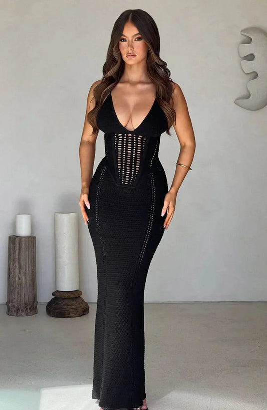 Black knit maxi dress with deep v-neckline, perforated corset detail, and floor-length fitted silhouette