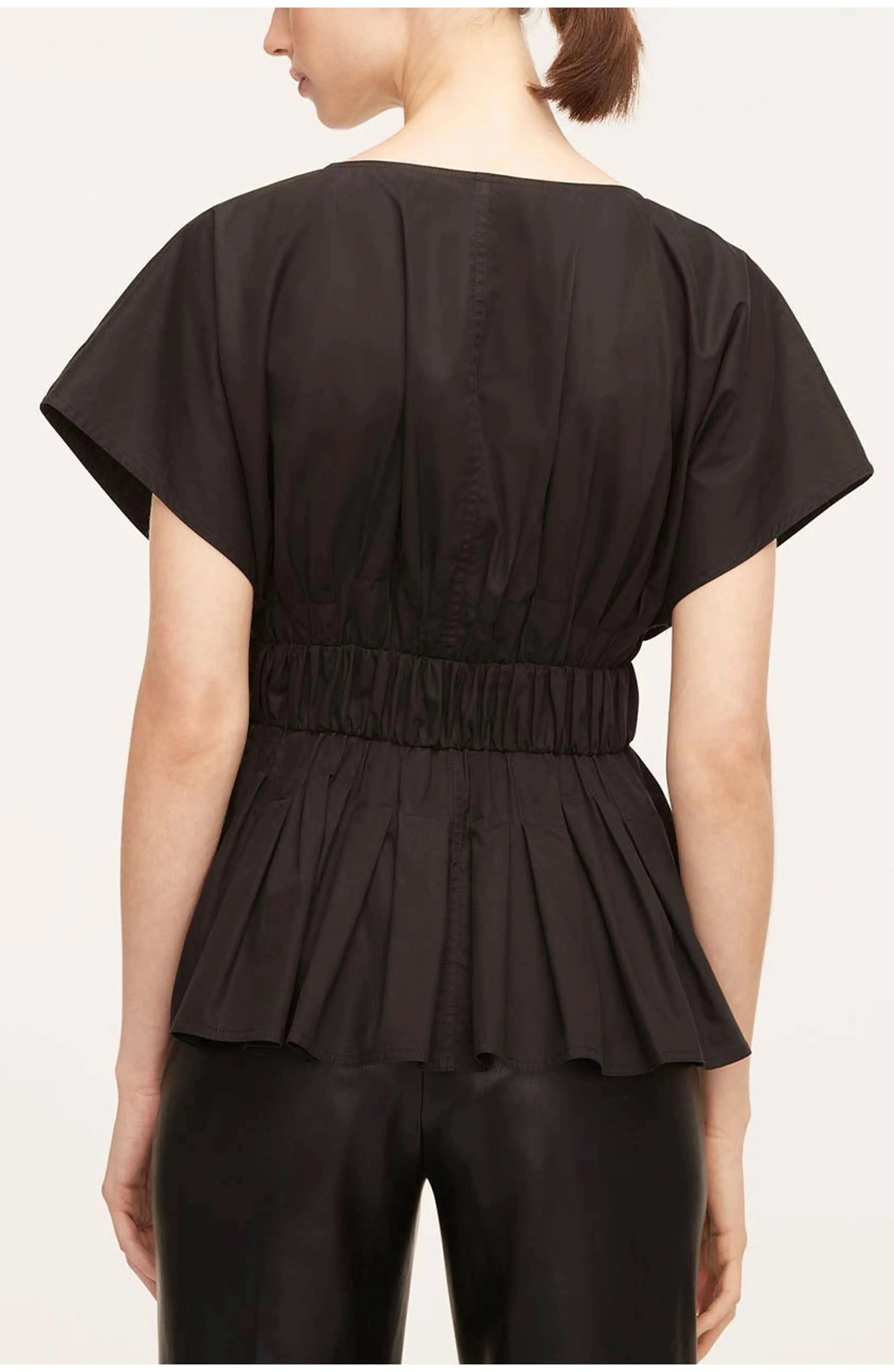 Back view of black belted blouse with center seaming and structured pleated design