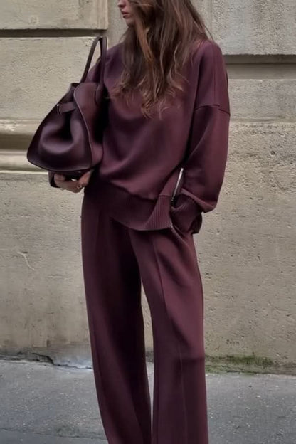 Burgundy knit sweater and wide-leg pants set worn with matching shoulder bag