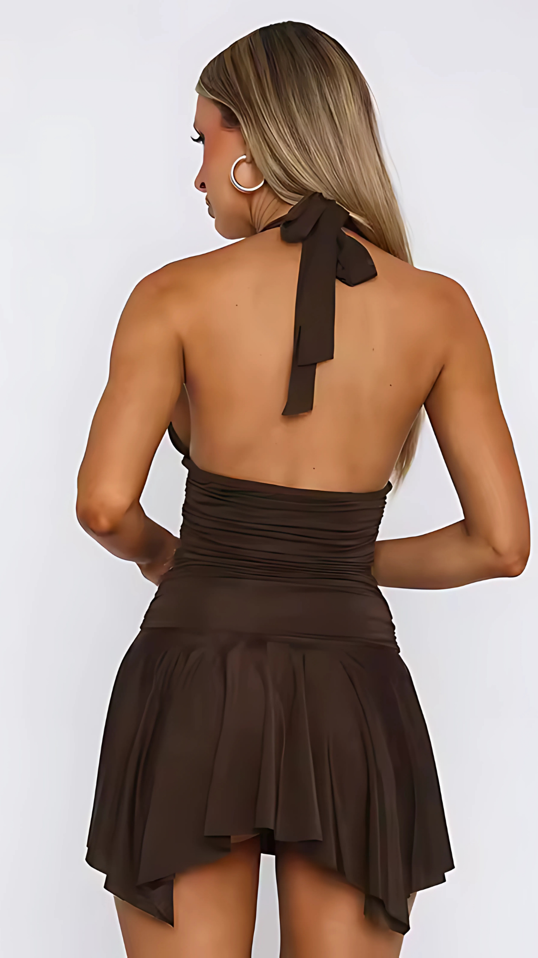 Back view of black halter mini dress with open back and asymmetrical hem