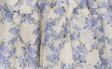 Close-up of blue hydrangea floral print fabric on cream maxi dress hem
