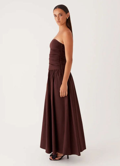 Burgundy strapless maxi dress with ruched bodice and flowing skirt, side view