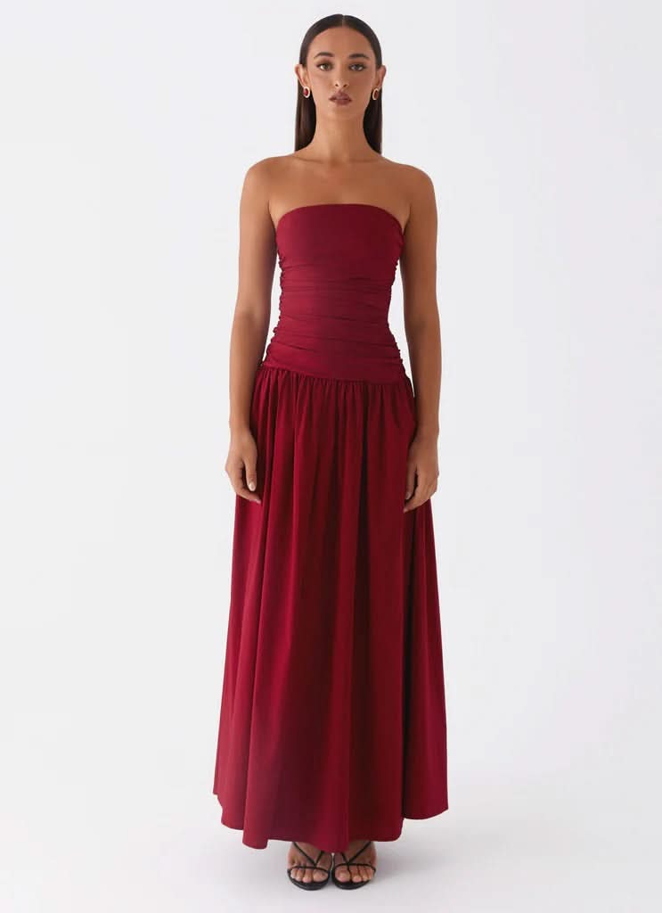 Burgundy strapless maxi dress with ruched bodice and floor-length skirt, front standing