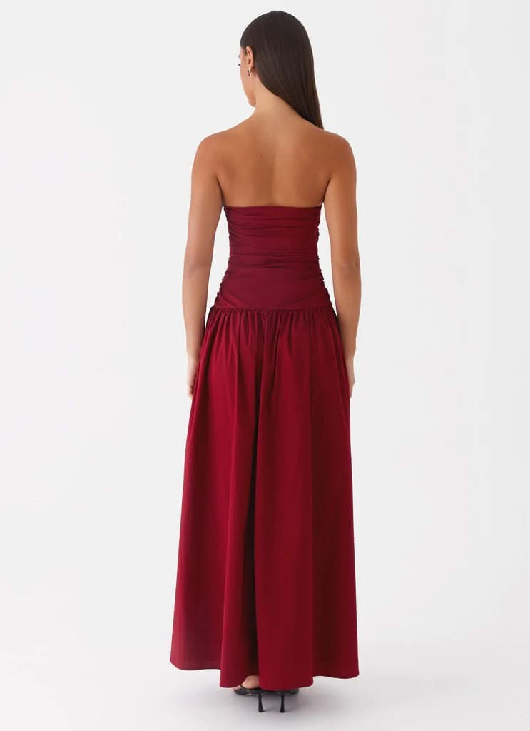 Burgundy strapless maxi dress with ruched bodice and flowing skirt, back view