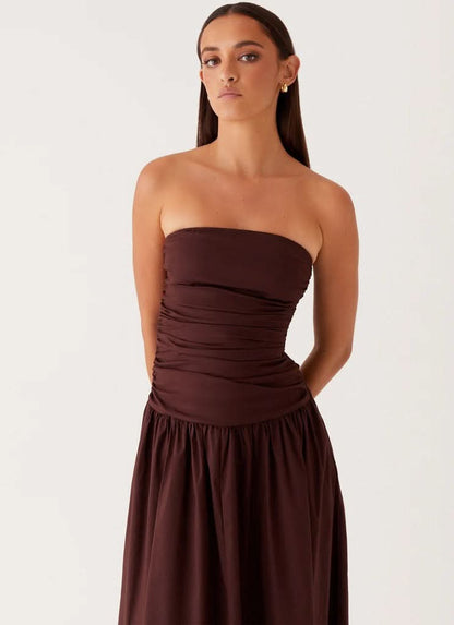 Deep burgundy strapless maxi dress with ruched waist and pleated skirt