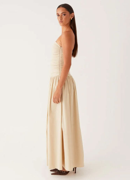 Side profile of cream strapless maxi dress with ruched bodice