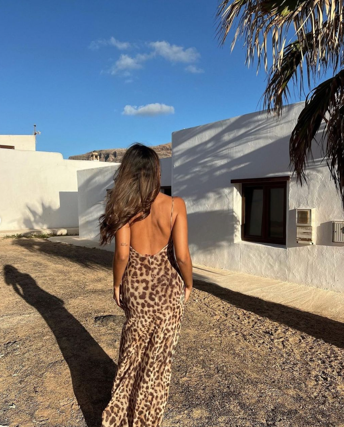 Backless leopard maxi dress worn outdoors showing full length silhouette