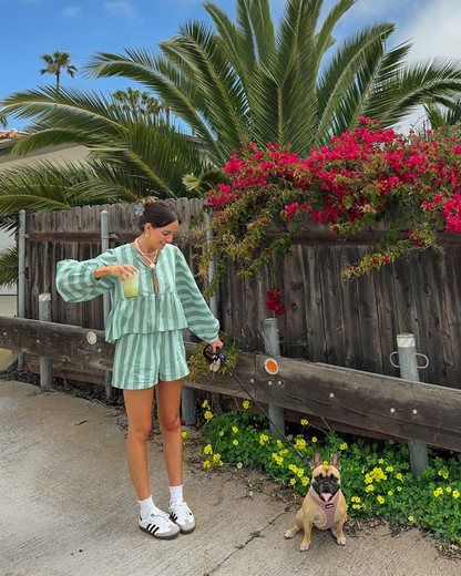 Women wearing mint striped two-piece lounge set with white sneakers outdoors