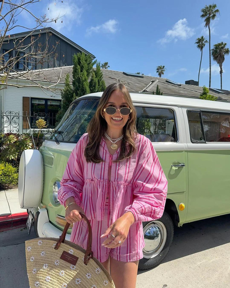 Pink striped button-up shirt and shorts set paired with accessories on model