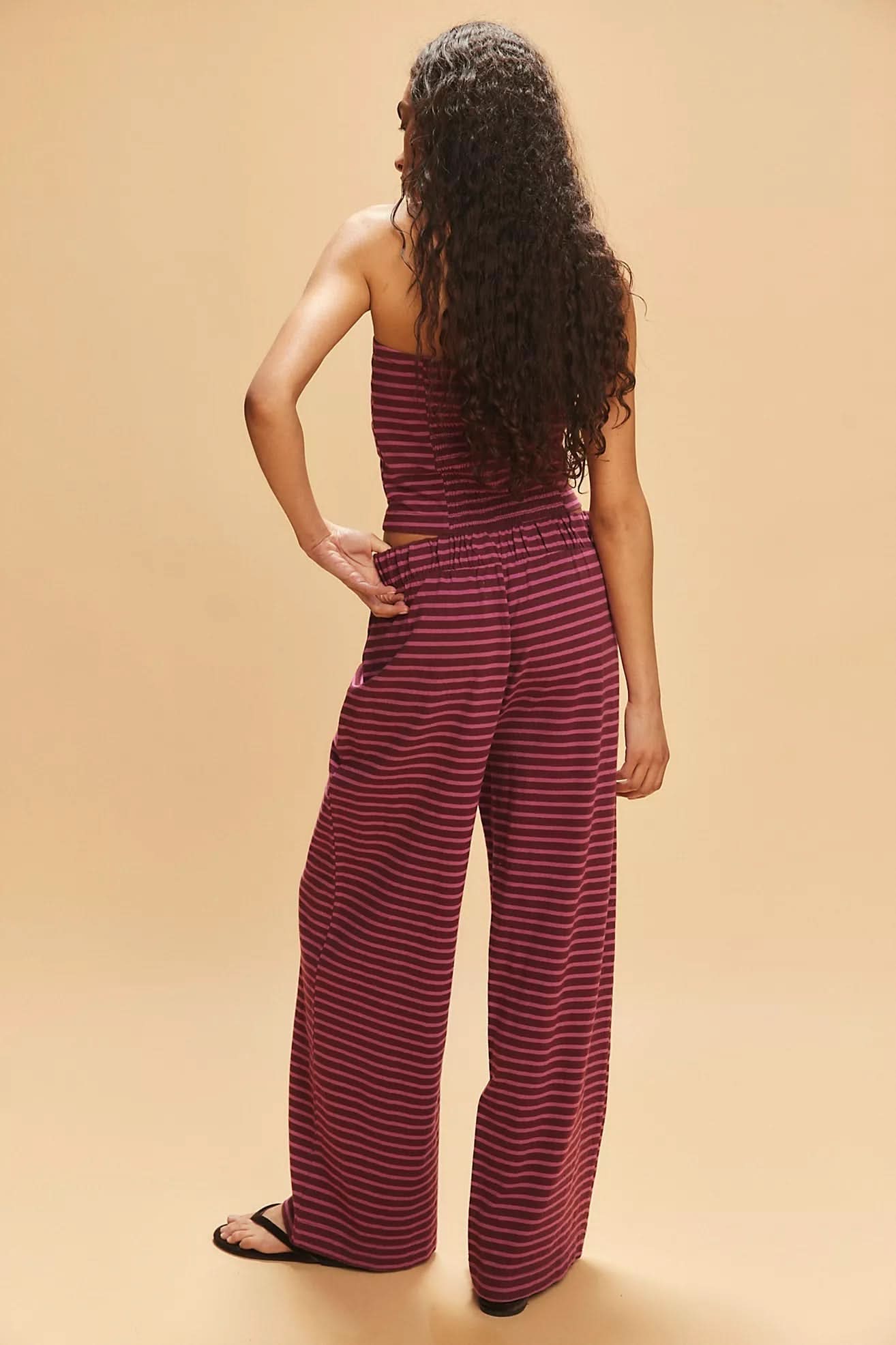 Back view of burgundy striped strapless crop top and pants set