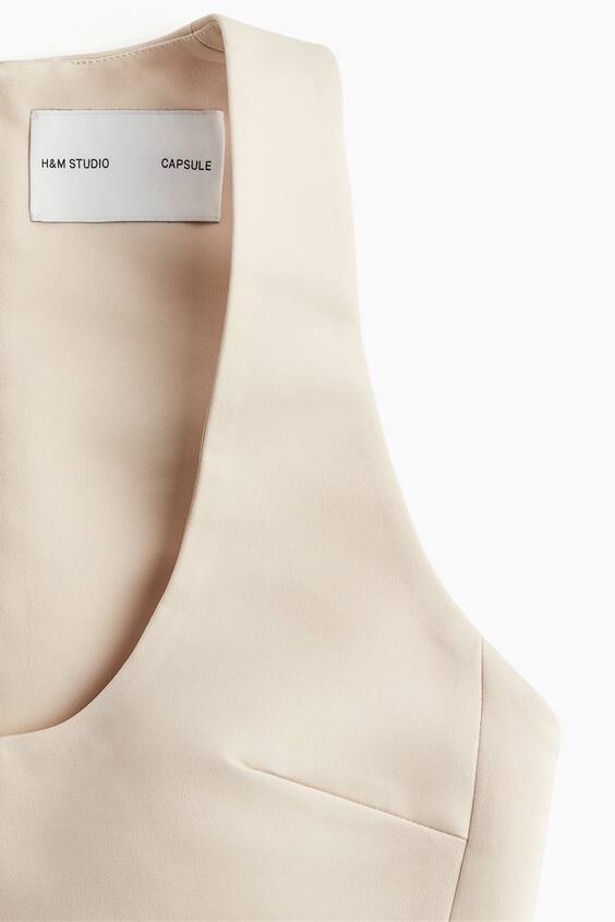 Back view of cream maxi dress showing U-shaped neckline and center zip closure