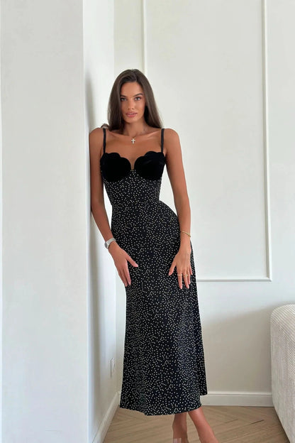 Black polka dot midi dress side view showing fitted bodice and mid-calf length