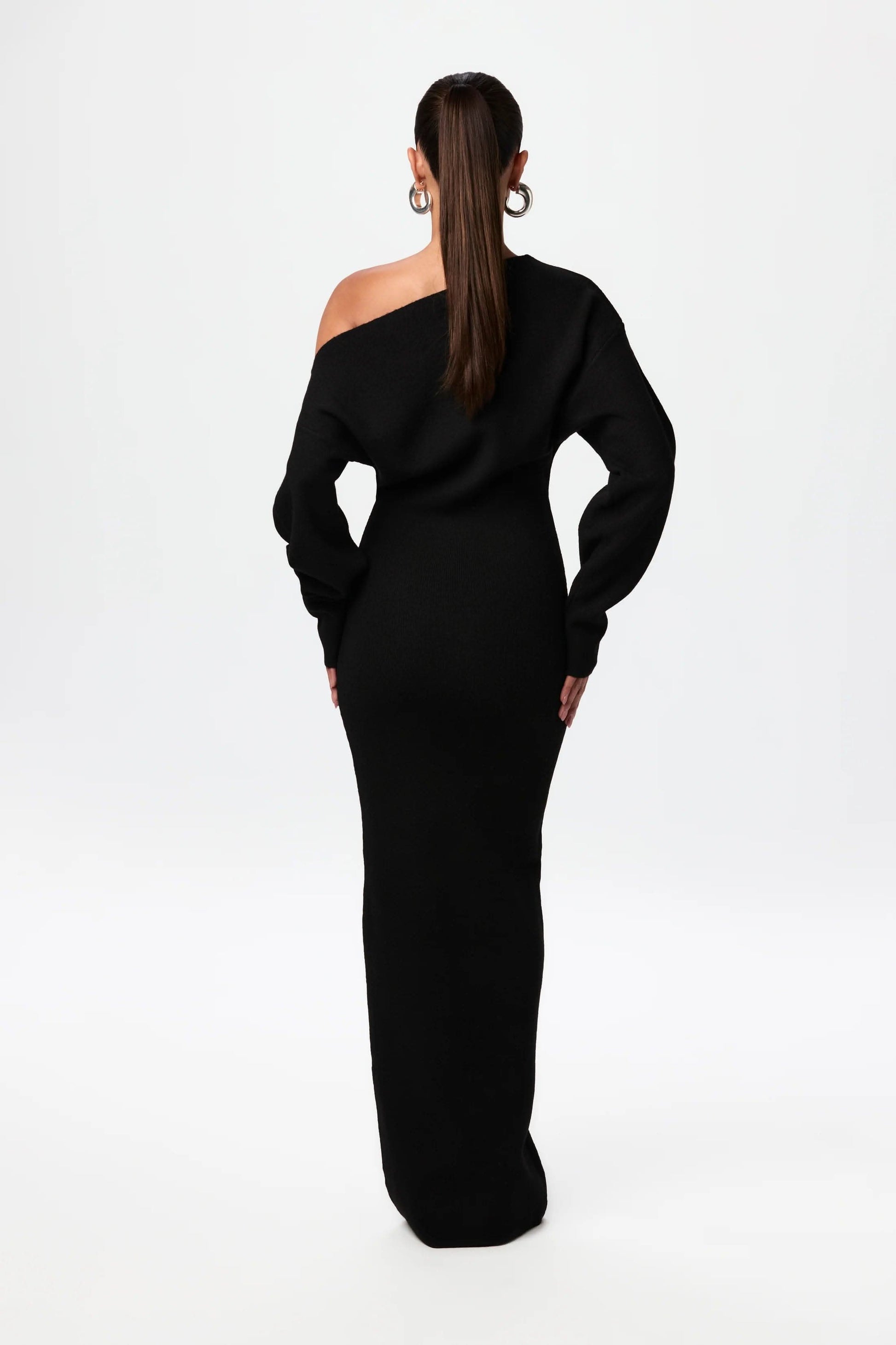 Back view of black off-shoulder knit maxi dress showing draped neckline