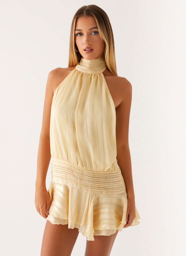 Cream pleated chiffon halter mini dress with ruched waist and flutter hem