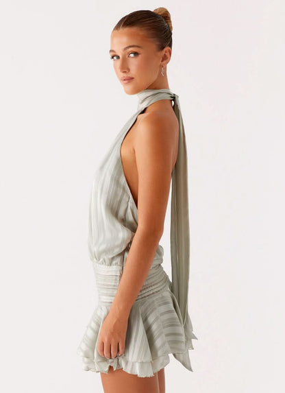 Side angle of sage green chiffon mini dress with open back and long tie detail