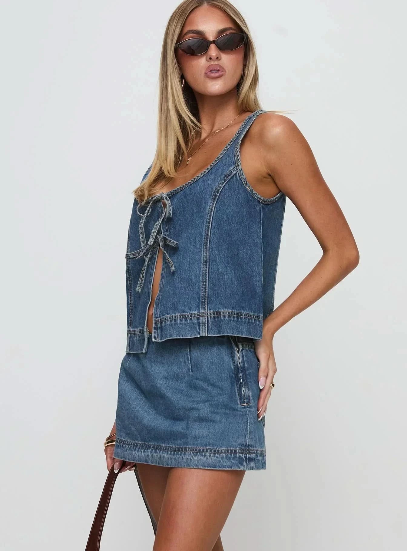 Side view of denim mini set showing cropped vest silhouette and A-line skirt proportions
