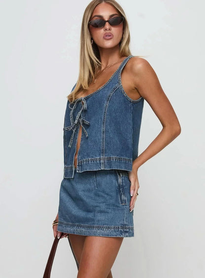 Side view of denim mini set showing cropped vest silhouette and A-line skirt proportions