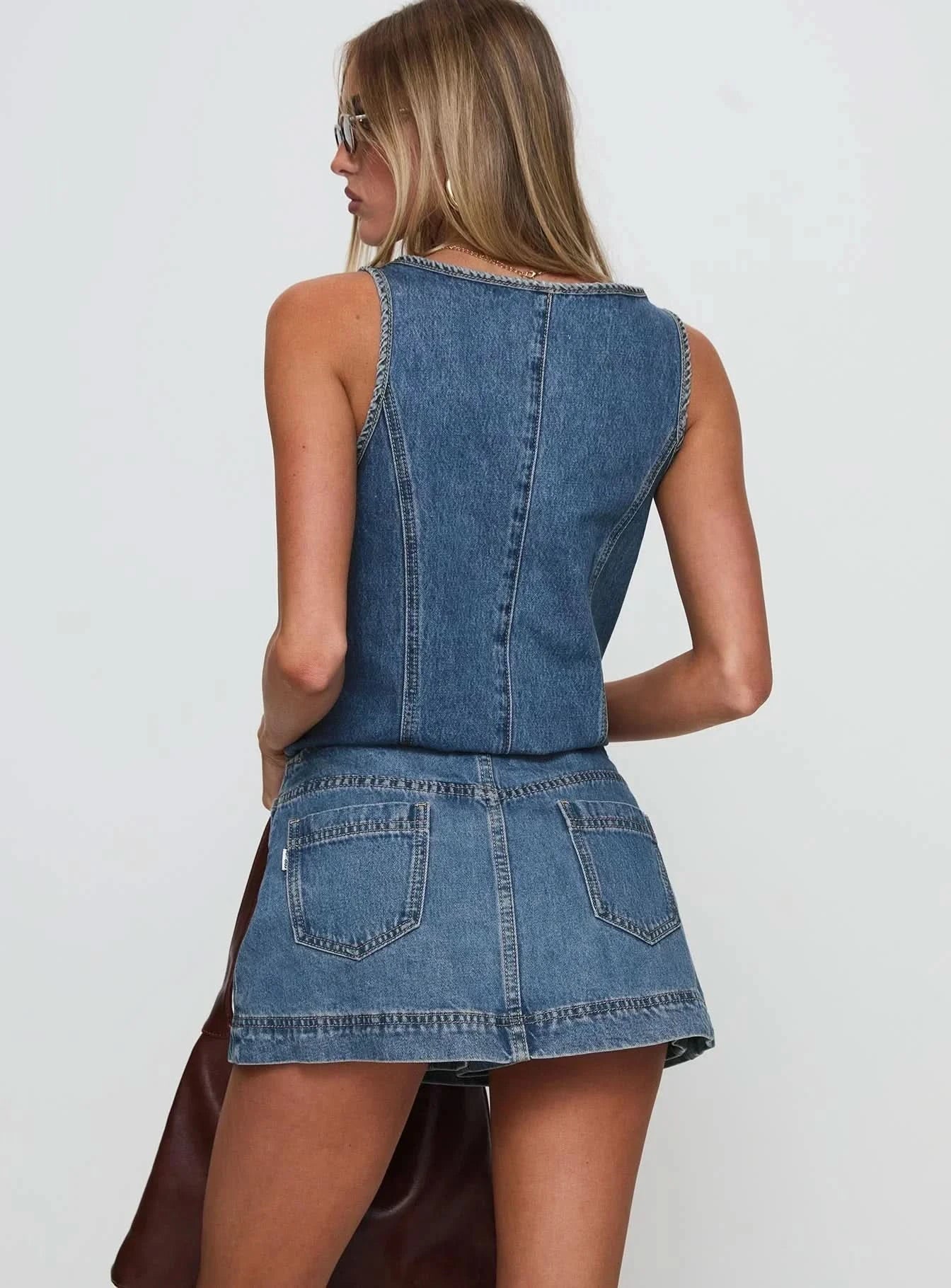 Back view of blue denim mini skirt showing center seam and A-line construction with topstitching