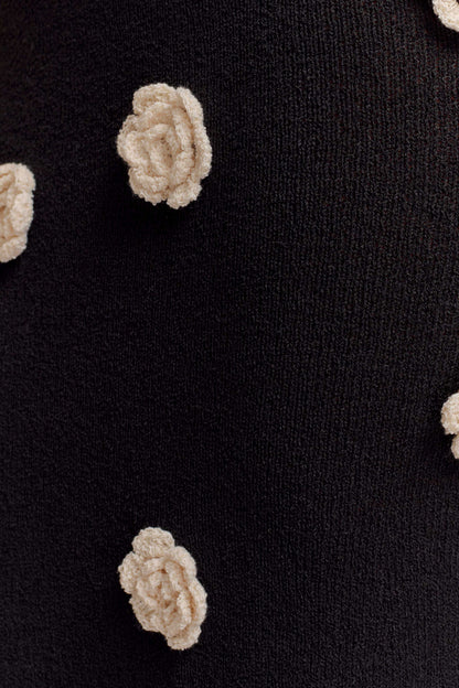 Close-up of cream textured flower appliqué on black fabric