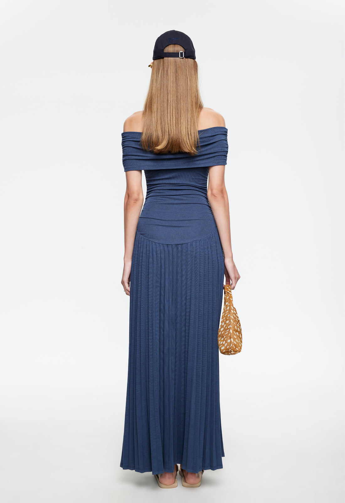 Back view of navy off-shoulder maxi dress with pleated floor-length skirt