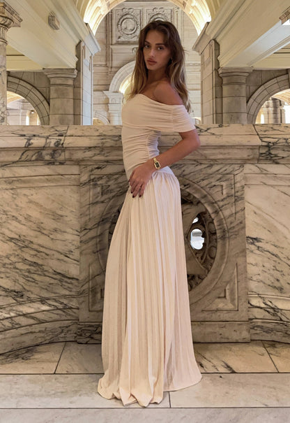 Cream shoulder maxi dress side view showing ruched waist and flowing pleated hem