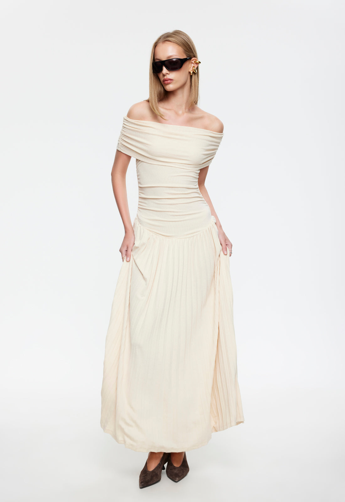 Cream off-shoulder maxi dress front detail showing ruched bodice and pleated skirt