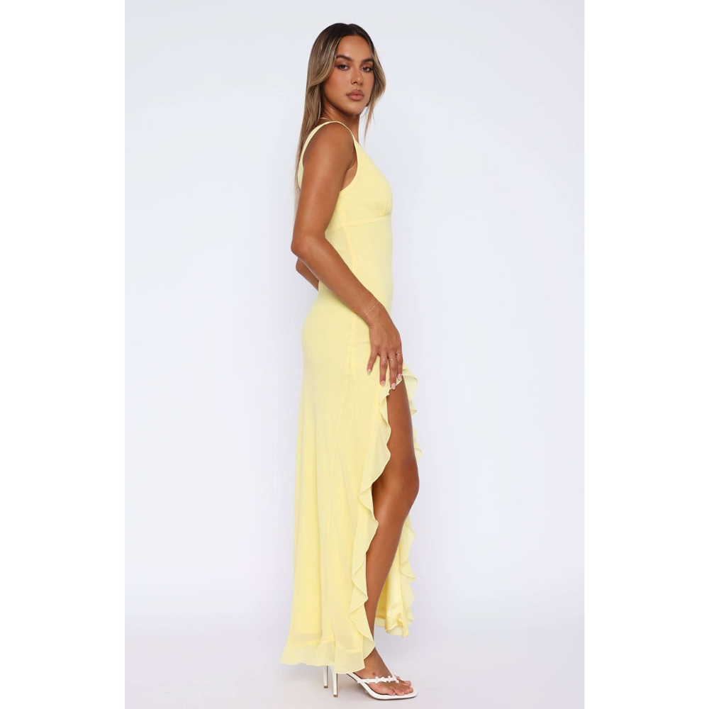 Side view of yellow maxi dress with flowing ruffled skirt detail