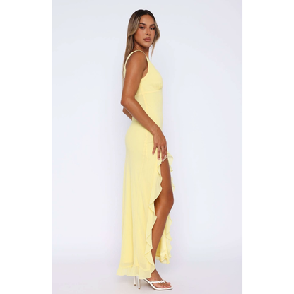 Side view of yellow maxi dress with flowing ruffled skirt detail